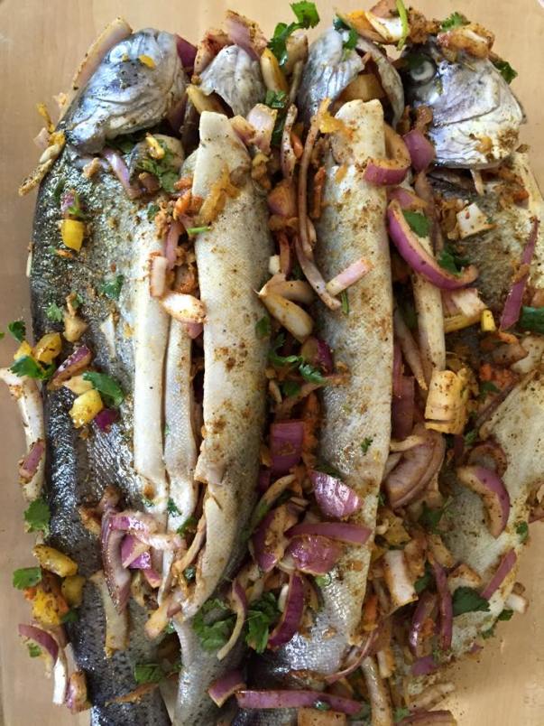 Trout fish with onions, bell peppers, garlic, cilantro and spices.